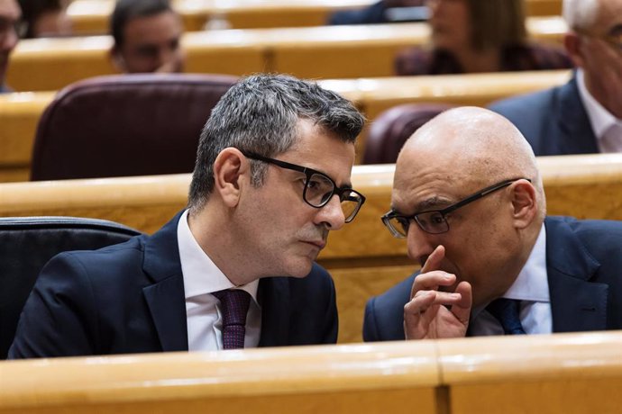 El ministro de Presidencia, Justicia y Relaciones con las Cortes, Félix Bolaños (i), conversa con otro senador durante una sesión plenaria en el Senado, a 20 de febrero de 2024, en Madrid (España).