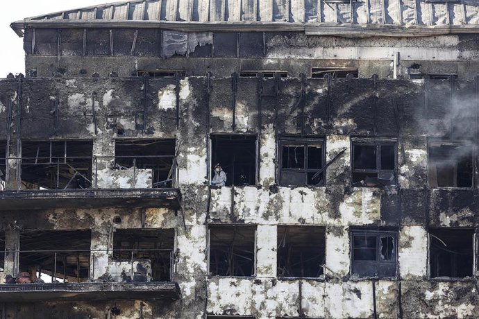 Un agente de la Policía Científica busca las causas del incendio en el edificio del barrio de Campanar