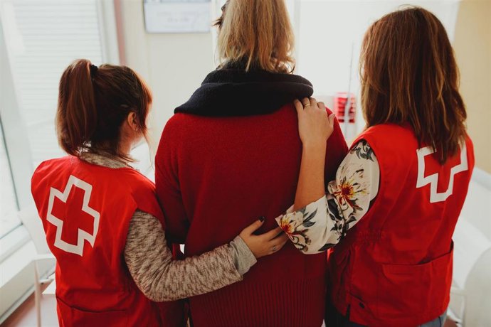 Voluntarias de Cruz Roja acompañan a una mujer.