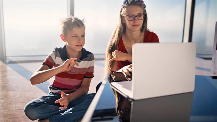 Dos niños usando un ordenador portátil