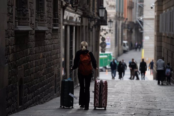 Una persona con dos maletas en Barcelona.