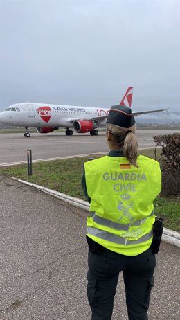 Una agente del Destacamento Fiscal y de Fronteras de la Guardia Civil de Córdoba frente al avión que voló a Praga.