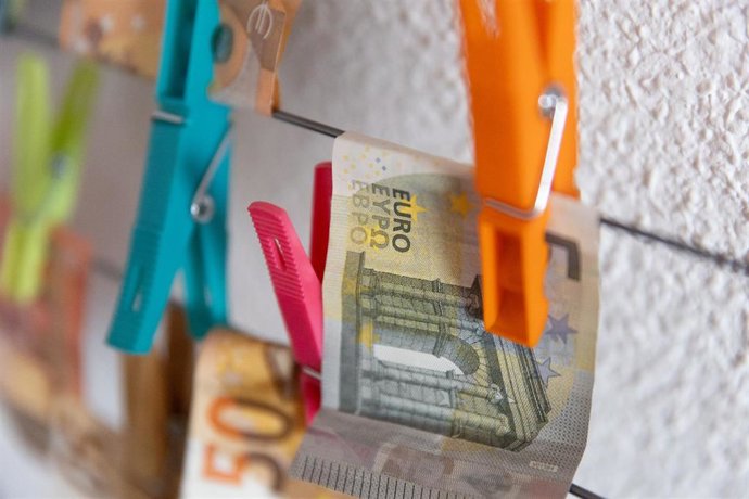 Archivo - Varios billetes sujetos con pinzas, en imagen de archivo. 