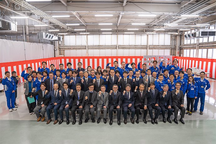 Trabajadores de Suzuki y SkyDrive, junto a los consejeros delegados de ambas compañías, en la ceremonia de inicio de la producción de sus coches voladores en Japón
