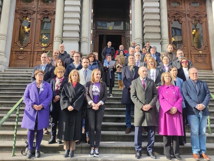 Diputadas y diputados de la Junta General en la lectura de la declaración de la Junta de Portavoces por el 8-M, leída por la recientemente jubilada archivera del parlamento, Josefina Velasco