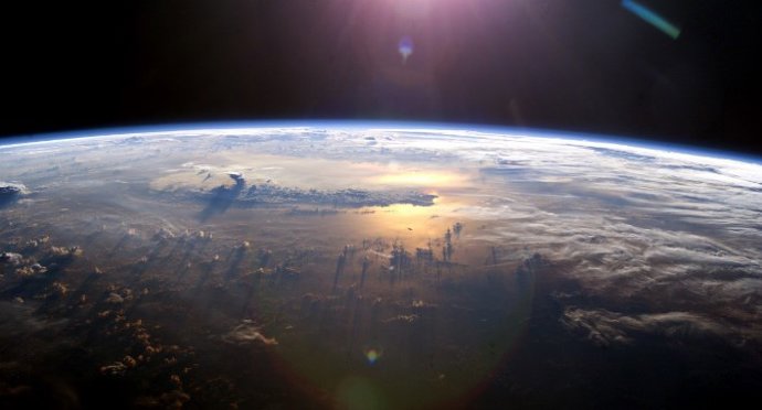 Vista del horizonte de la Tierra mientras el sol se pone sobre el Pacífico.