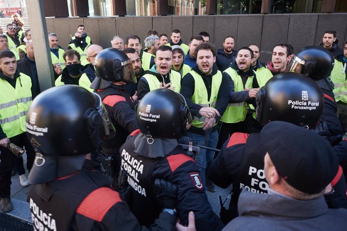 Varias personas protestan y se enfrentan a la Policía Foral de Navarra, en la parte trasera del Parlamento de Navarra.