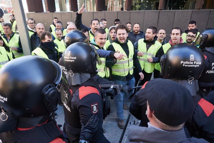 Varias personas protestan y se enfrentan a la Policía Foral en el exterior del Parlamento de Navarra durante el debate de Presupuestos de 2024.