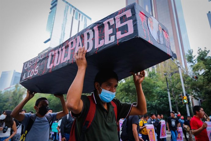 Archivo - 26 September 2021, Mexico, Mexico City: Protesters carry a coffin with photos of politicians during a protest to demand justice for the 43 students from Ayotzinapa, seven years after their forced disappearance in Iguala, Guerrero. 