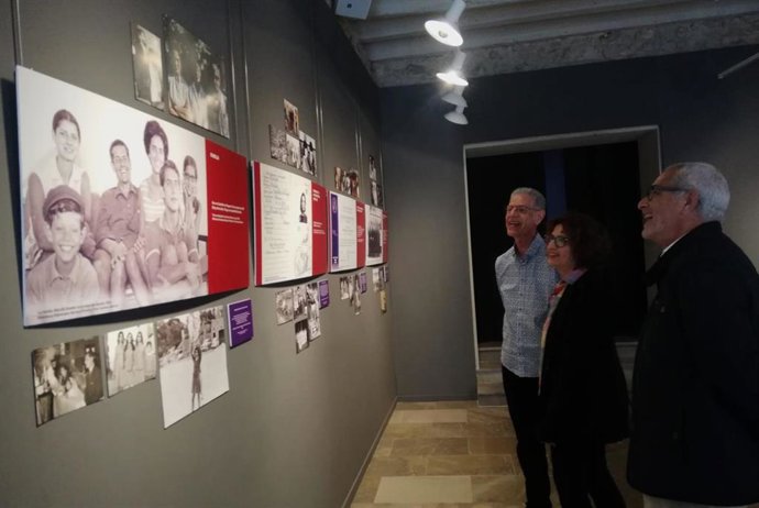 Los hermanos de Carmen Alborch miran una imagen de la muestra dedicada a la política socialista que se ha inaugurado en Logroño.