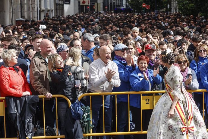 Una fallera saluda durante una masclet de las Fallas 2024