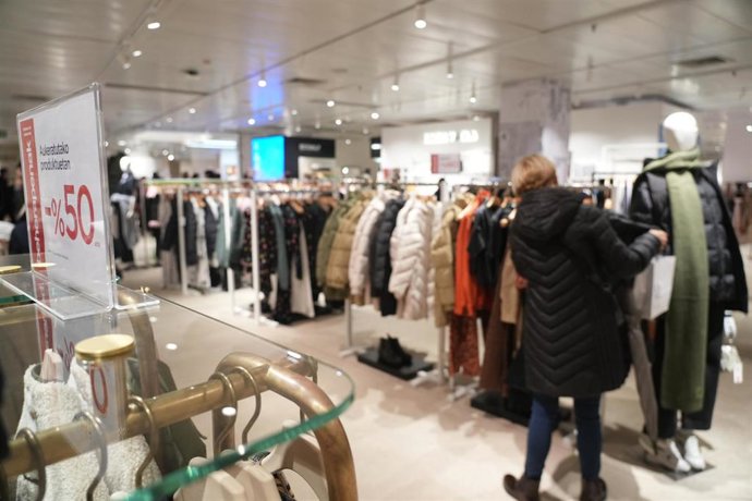 Archivo - Una mujer revisa ropa en el centro comercial El Corte Inglés Gran Vía, 
