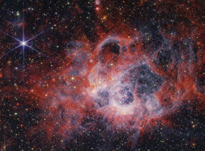 Esta imagen de la NIRCam del telescopio espacial James Webb  de la región de formación estelar NGC 604 muestra cómo los vientos estelares de estrellas jóvenes, brillantes y calientes crean cavidades en el gas y el polvo circundantes