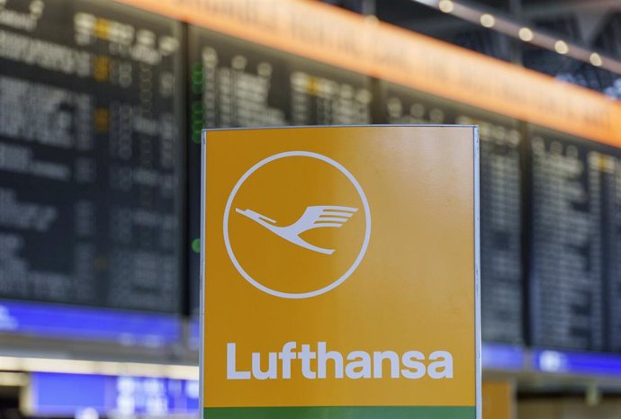 06 March 2024, Hesse, Frankfurt/Main: The Lufthansa airline logo stands in front of the display board in the departure hall in Terminal 1. 
