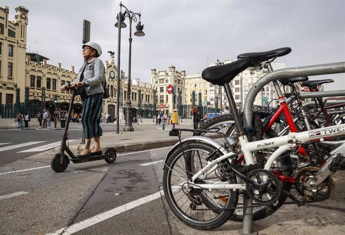 Archivo - Una mujer con un patinete eléctrico en un carril bici del centro de Valencia