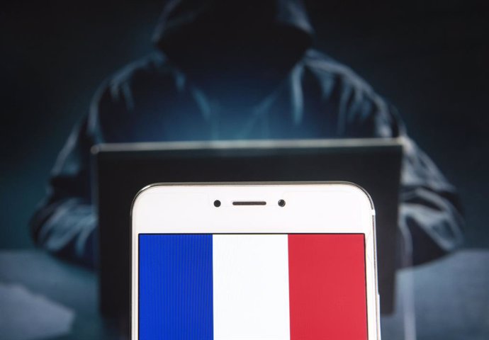 Archivo - April 5, 2019 - Hong Kong - In this photo illustration a French Republic flag is seen on an Android mobile device with a figure of hacker in the background.