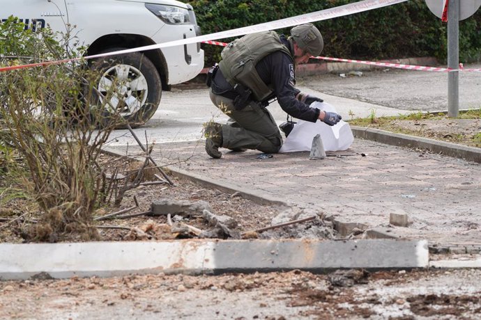 Un mimebro de las fuerzas de seguridad de Israel trabaja en el lugar donde impactó un proyectil disparado por Hezbolá desde Líbano contra Kiryat Shmona (archivo)