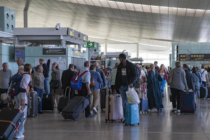 Archivo - Un grupo de personas con maletas en el aeropuerto de Barcelona.
