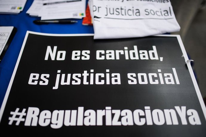 Archivo - Un cartel donde se puede leer "No es caridad, es justicia social" en una concentración para exigir la regularización de todas las personas migrantes en situación administrativa irregular, a 19 de febrero de 2022, en Madrid (España). 