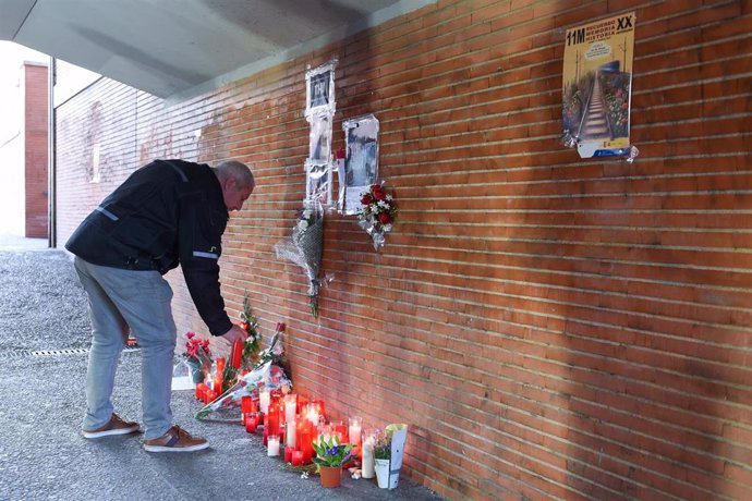 Varias personas durante una concentración de homenaje a las víctimas del atentado del 11M en su 20 aniversario, frente al monumento conmemorativo Peridis, en la estación de Renfe de El Pozo.