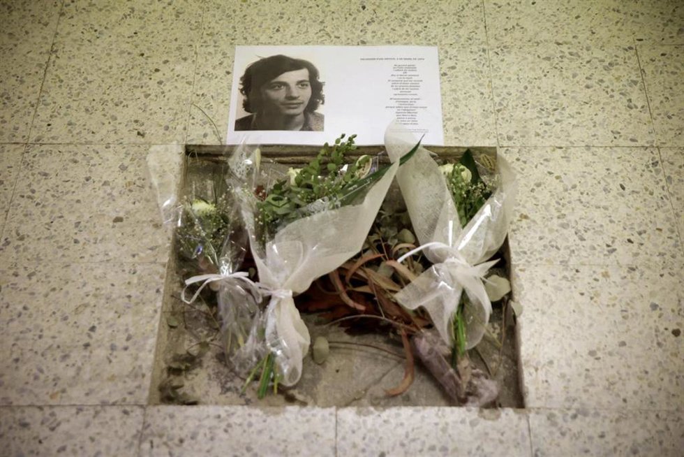 Una fotografía de Salvador Puig Antich y flores en el lugar donde se instaló el garrote vil para ejecutarlo.