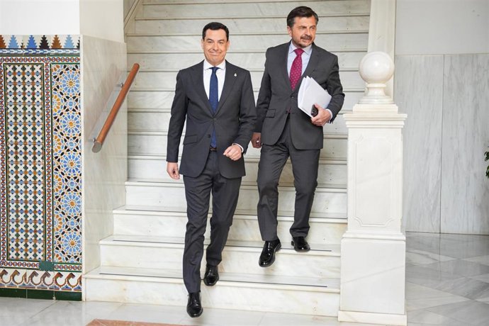 El presidente de la Junta de Andalucía, Juanma Moreno (i); junto al portavoz del grupo parlamentario PP-A, Toni Martín (d), a su llegada a la sesión de control del Parlamento andaluz en una foto de archivo.