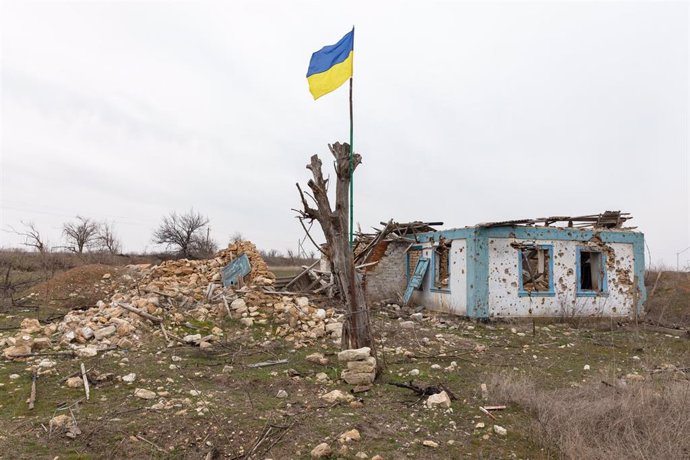 March 2, 2024, Mykolaiv Region, Ukraine: A Ukrainian flag is seen attached to a damaged tree against the background of a residential building in a village in Mykolaiv region, which was completely destroyed by Russian troops. A typical scene of a Ukrainian