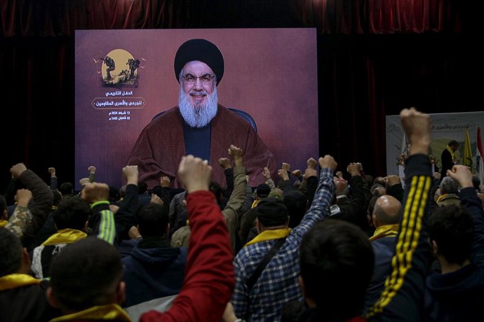 13 February 2024, Lebanon, Beirut: Supporters of the Iranian-backed Hezbollah group raise their fists and cheer, as they listen to a speech by Hassan Nasrallah, Secretary-general of Hezbollah, who appears via a video link, during an event to mark the "W