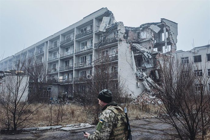 Archivo - Un soldado de Ucrania camina frente a un edificio alcanzado por un ataque del Ejército de Rusia contra la ciudad de Marinka, en la provincia de Donetsk (archivo)