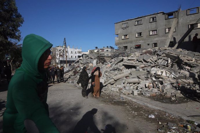 Palestinos caminan junto a un edificio destruido por los bombardeos del Ejército de Israel contra la ciudad de Rafá, en el sur de la Franja de Gaza (archivo)