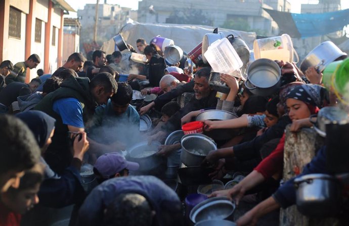 Un grupo de personas recibe ayuda humanitaria en la Franja de Gaza
