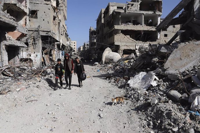 Archivo - Palestinos caminan entre edificios destruidos por los bombardeos del Ejército de Israel contra la ciudad de Gaza, en el norte de la Franja de Gaza (archivo)