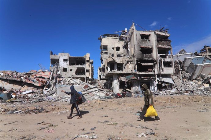 Palestinos frente a edificios destruidos por los bombardeos del Ejército de Israel contra la ciudad de Rafá, en el sur de la Franja de Gaza (archivo)