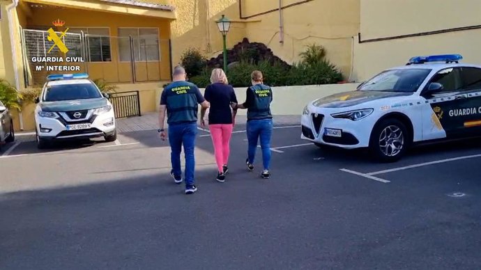 Una pareja de guardias civiles acompañan a la detenida por sustraer 24.000 euros a su yerno en Gran Canaria