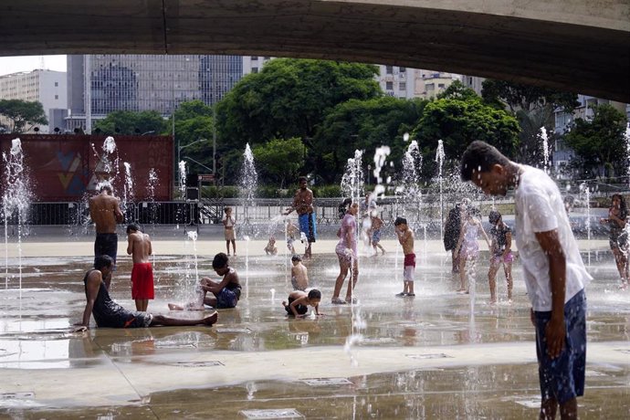 Archivo - Gente refrescándose en una fuente en Brasil