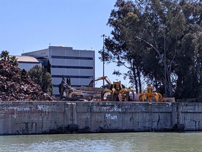 Máquinas trabajando en la demolición de la planta de hormigón sin uso que había en los suelos del muelle de Tablada del Puerto de Sevilla.