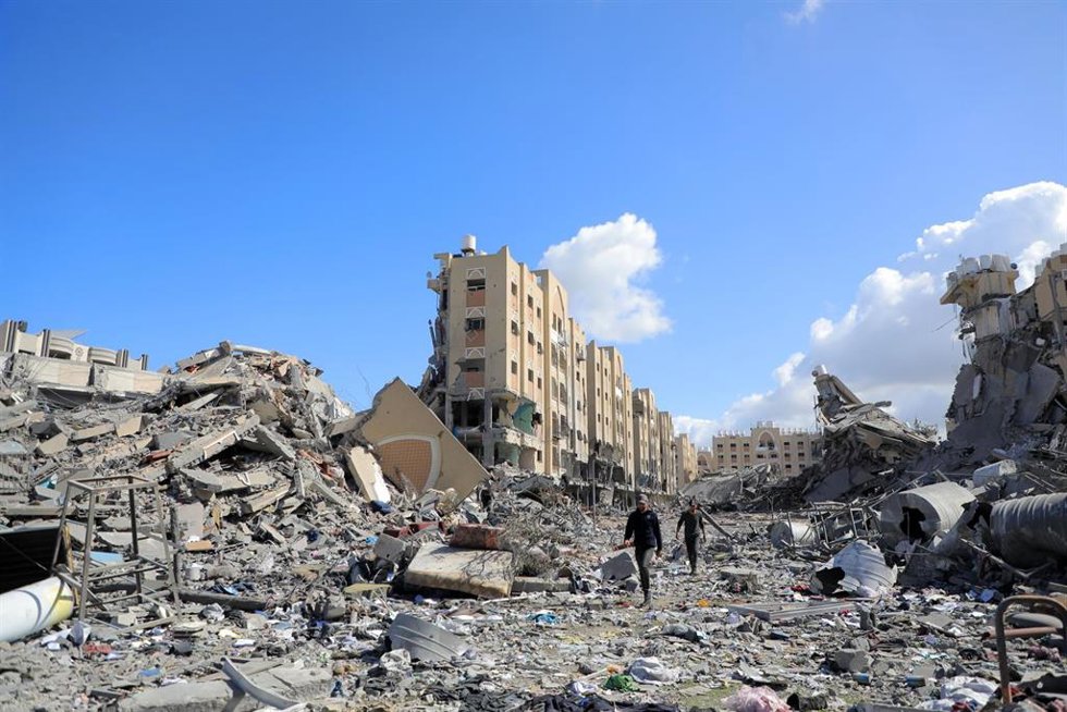 Palestinos caminando entre edificios destruidos por los bombardeos del Ejército de Israel contra la ciudad de Jan Yunis, en el sur de la Franja de Gaza (archivo)
