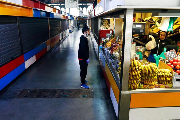 Archivo - Un cliente compra en uno de los pocos puestos del Mercado de Atarazanas