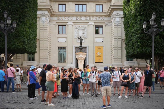 Archivo - Turistas prestan atención al guía que les explica las curiosidades de la ciudad de Sevilla.