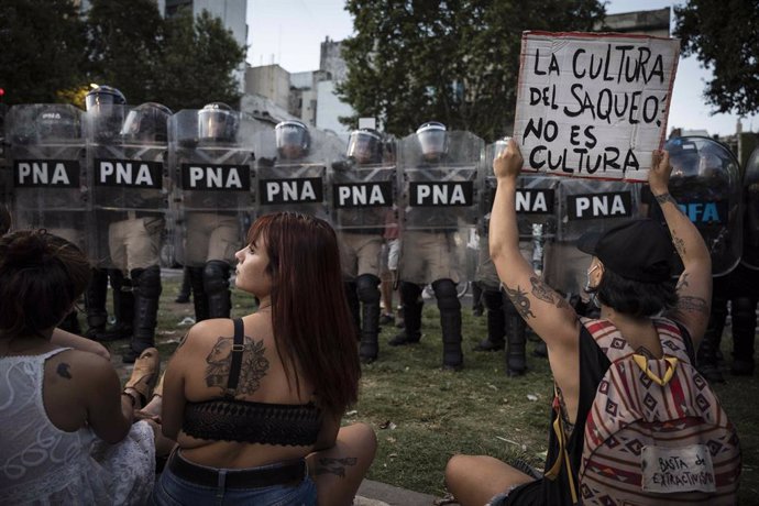 Archivo - January 31, 2024, Buenos Aires, Argentina: Young protesters sit and hold a placard reading ''the culture of looting is not culture'' infront of a line of police officers during the demonstration. The Omnibus Law of more than 600 articles present