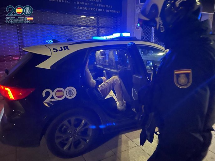 Uno de los detenidos, sentado dentro del coche policial.