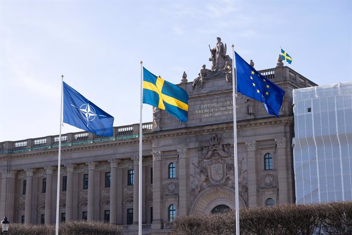 STOCKHOLM, March 18, 2024  -- This photo taken on March 18, 2024 shows flag of the North Atlantic Treaty Organization (NATO) (L) flying alongside the Swedish flag (M) and the European Union flag in front of the Swedish Parliament in Stockholm, Sweden. The