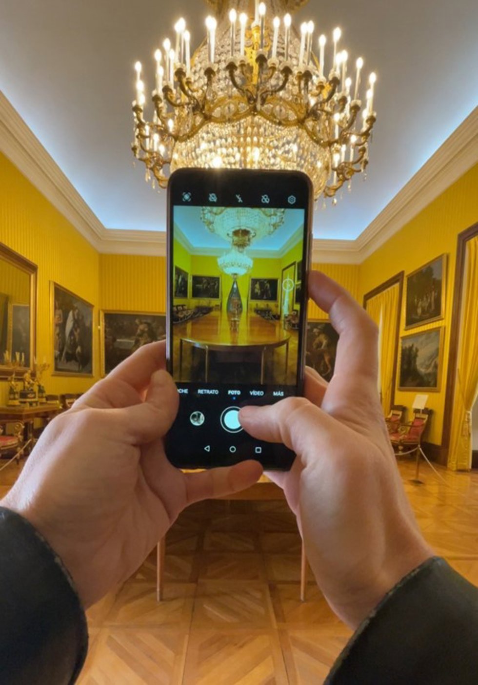 Un visitante toma una foto dentro de un edificio de Patrimonio oNacional.