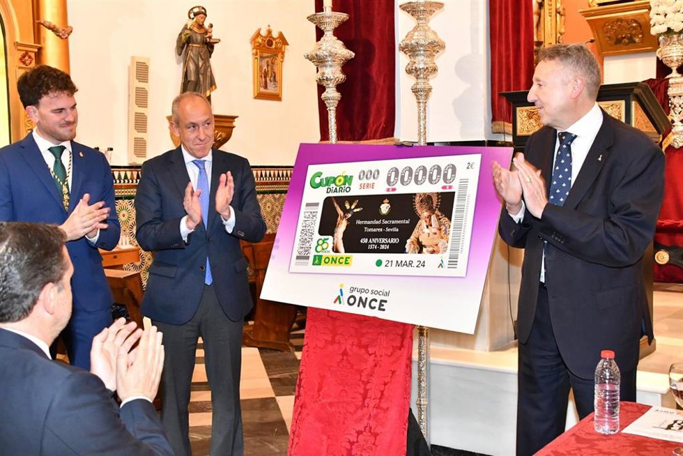 El alcalde de Tomares y el delegado territorial de la ONCE, junto al cupón dedicado a la hermandad sacramental por su 450 aniversario.