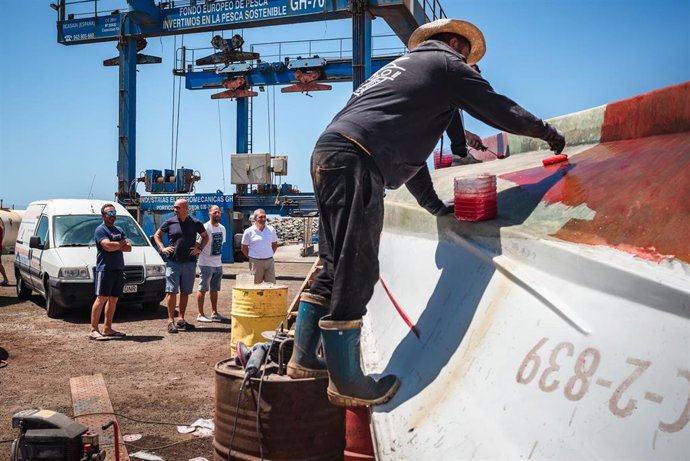 Un pescador arregla su embarcación