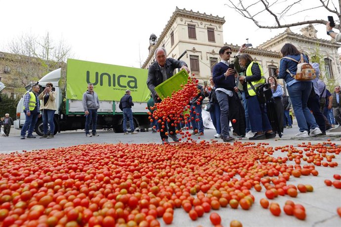 Agricultores tiran tomates durante la tractorada de este viernes en Granada.
