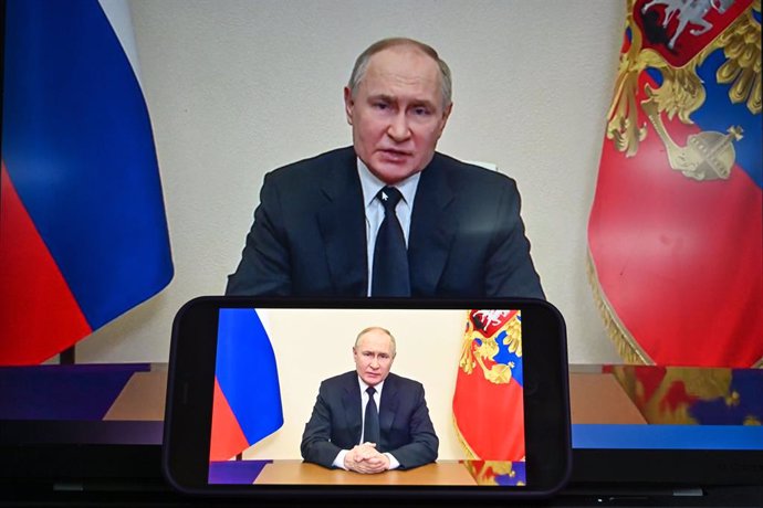MOSCOW, March 23, 2024  -- This photo taken in Moscow, Russia on March 23, 2024 shows screens displaying Russian President Vladimir Putin speaking in a televised address to the nation. Putin said Saturday all four perpetrators of the Moscow terrorist atta