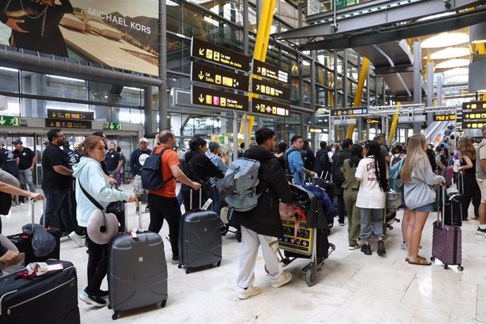 Archivo - Varias personas con maletas en el Aeropuerto Adolfo Suárez-Madrid Barajas,