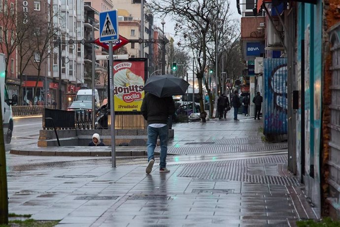 Archivo - Un hombre se protege de la lluvia con un paraguas durante la borrasca ‘Karlotta’, a 9 de febrero de 2024, en Madrid (España).