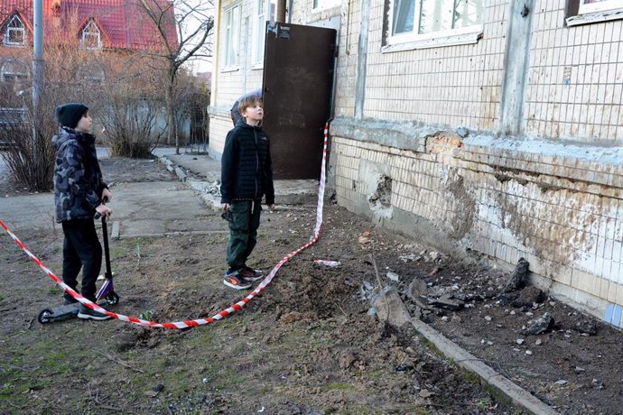 Unos niños inspeccionan uno de los lugares afectados por un reciente ataque de Rusia sobre Kiev, Ucrania